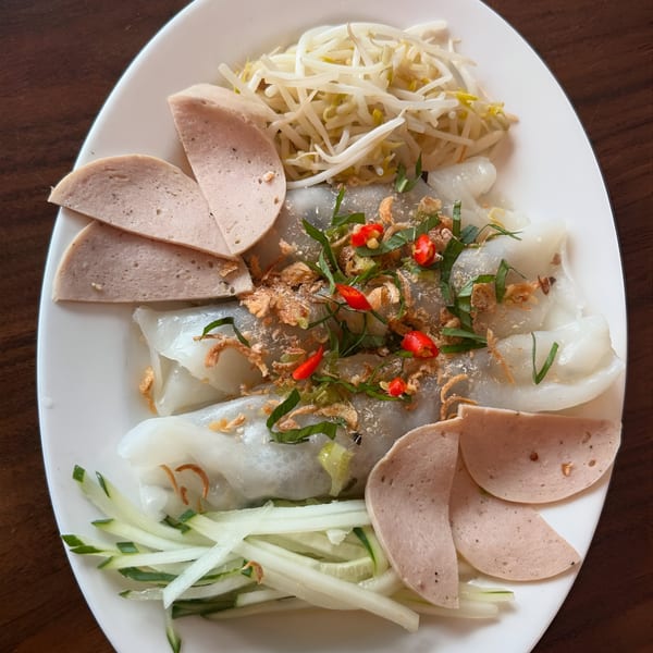 Vietnamese steamed rice rolls (Banh Cuon) with sliced pork sausage, bean sprouts, and fresh herbs.